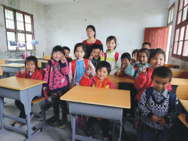 公司為一山村小學捐贈一批課桌椅，孩子們高興地和老師一起合影